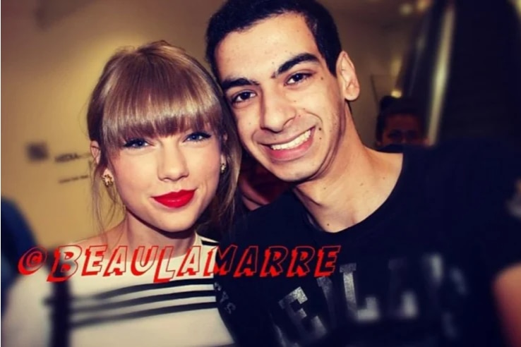 Beau Lamarre stands smiling beside celebrity Taylor Swift