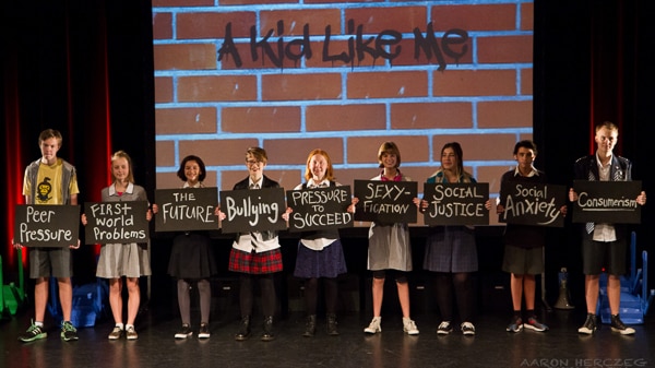 The cast of the production A Kid Like Me hold up the nine topic signs.
