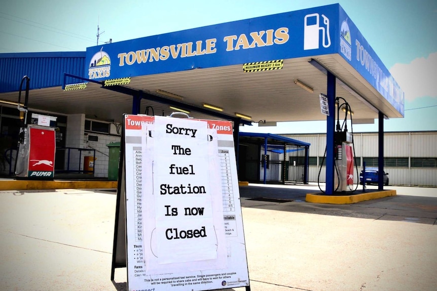 A sign that says "sorry the fuel is station is now closed" stands outside a fuel station owned by Townsville Taxis.
