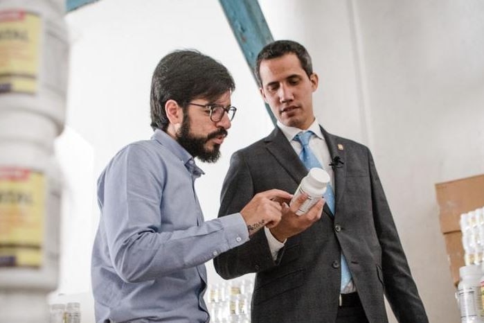 Juan Guaido holds a container of vitamin supplements.