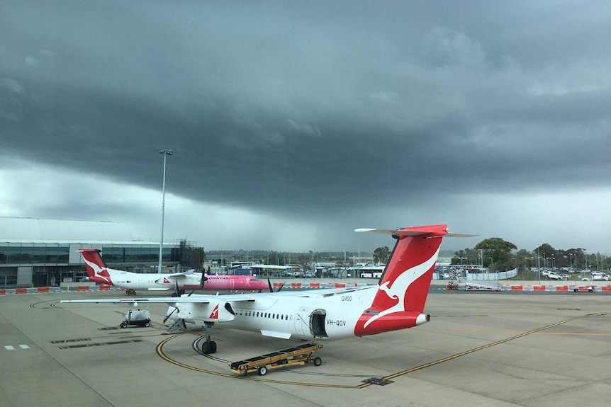 Planes on the tarmac at Brisbane airport with storm clouds on November 7, 2017.