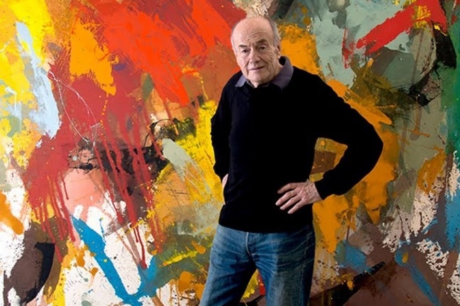 Sydney Ball stands in front of his art.