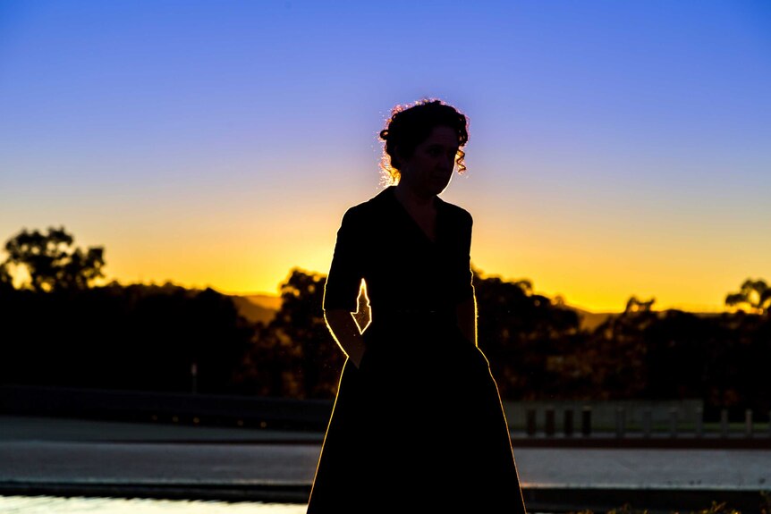 Silhouette of Crabb outside Parliament House in Canberra at sunrise.