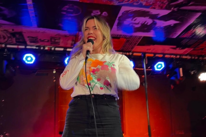 A woman performing stand up comedy on stage 