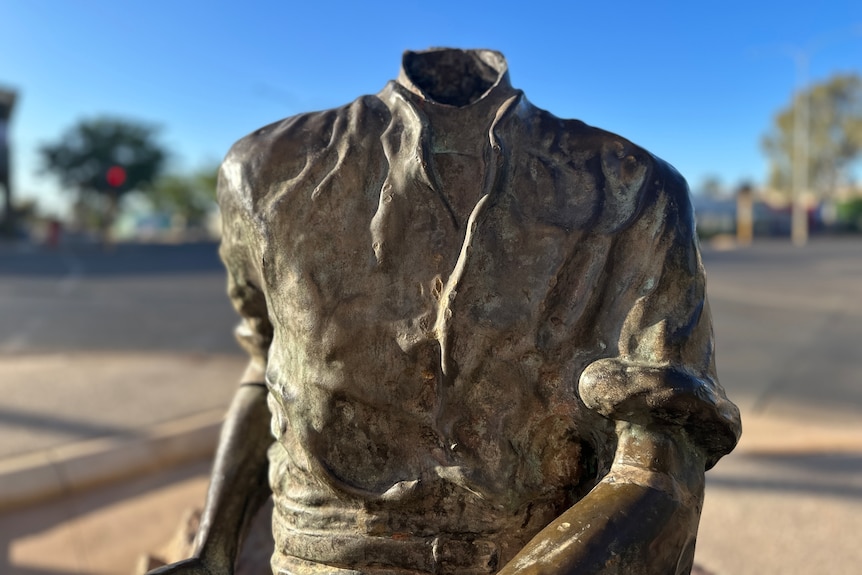 Close up of a statue of a man with its head missing