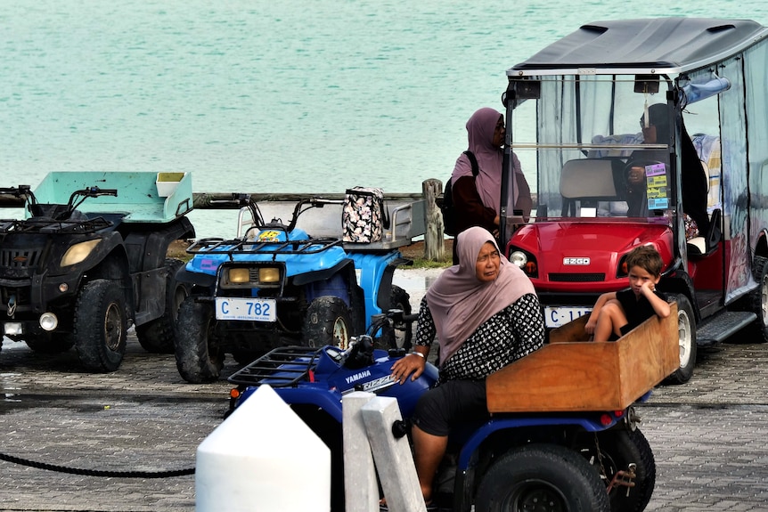 Cocos Malay people sitting on buggies on the jetty.