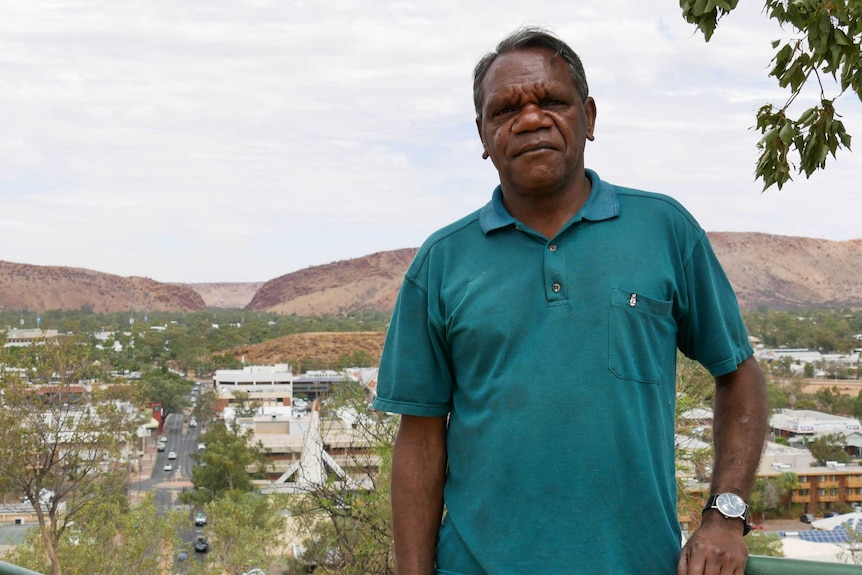 A man stands in front of The Gap in Alice Springs