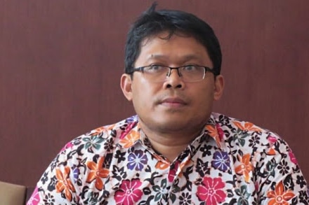 Riris Andono wearing glasses and a colorful shirt.