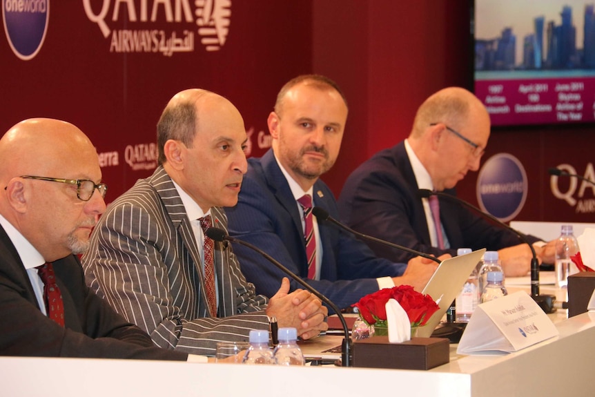 Four men from Qatar Airways, ACT Government and Canberra Airport sit at a table.