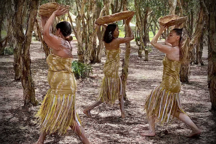 Three women performing traditional dance.