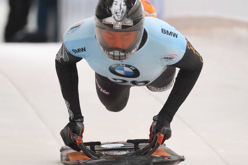 Nathan Crumpton jumps onto his sled at the start of his run down the chute.