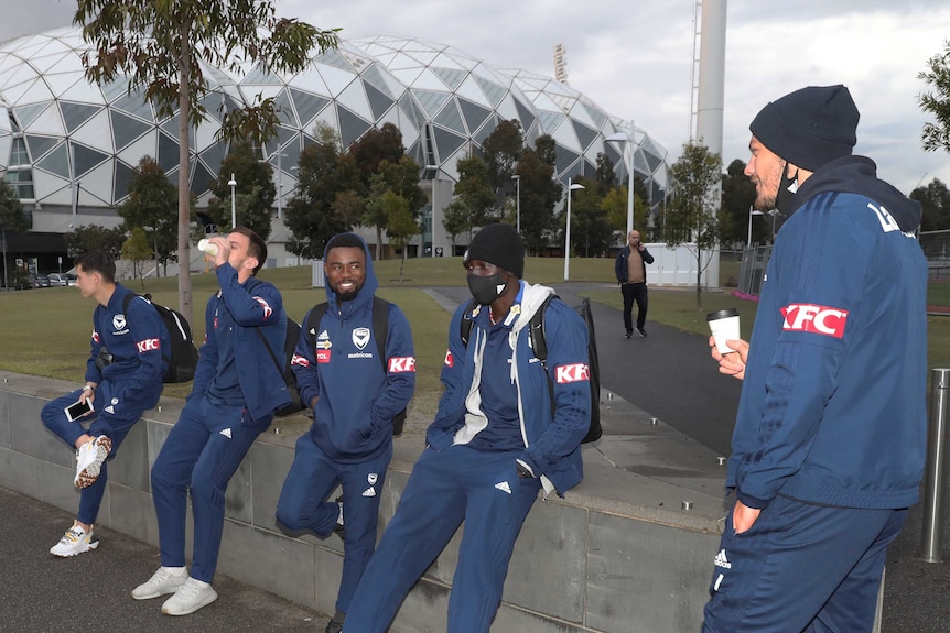 Five Melbourne Victory A-League players gather outside AAMI Park before flying to Sydney.