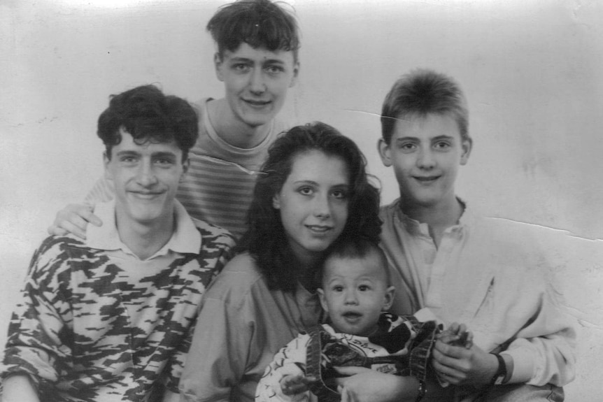 Black and white photo of Kathrin and her siblings smiling to camera