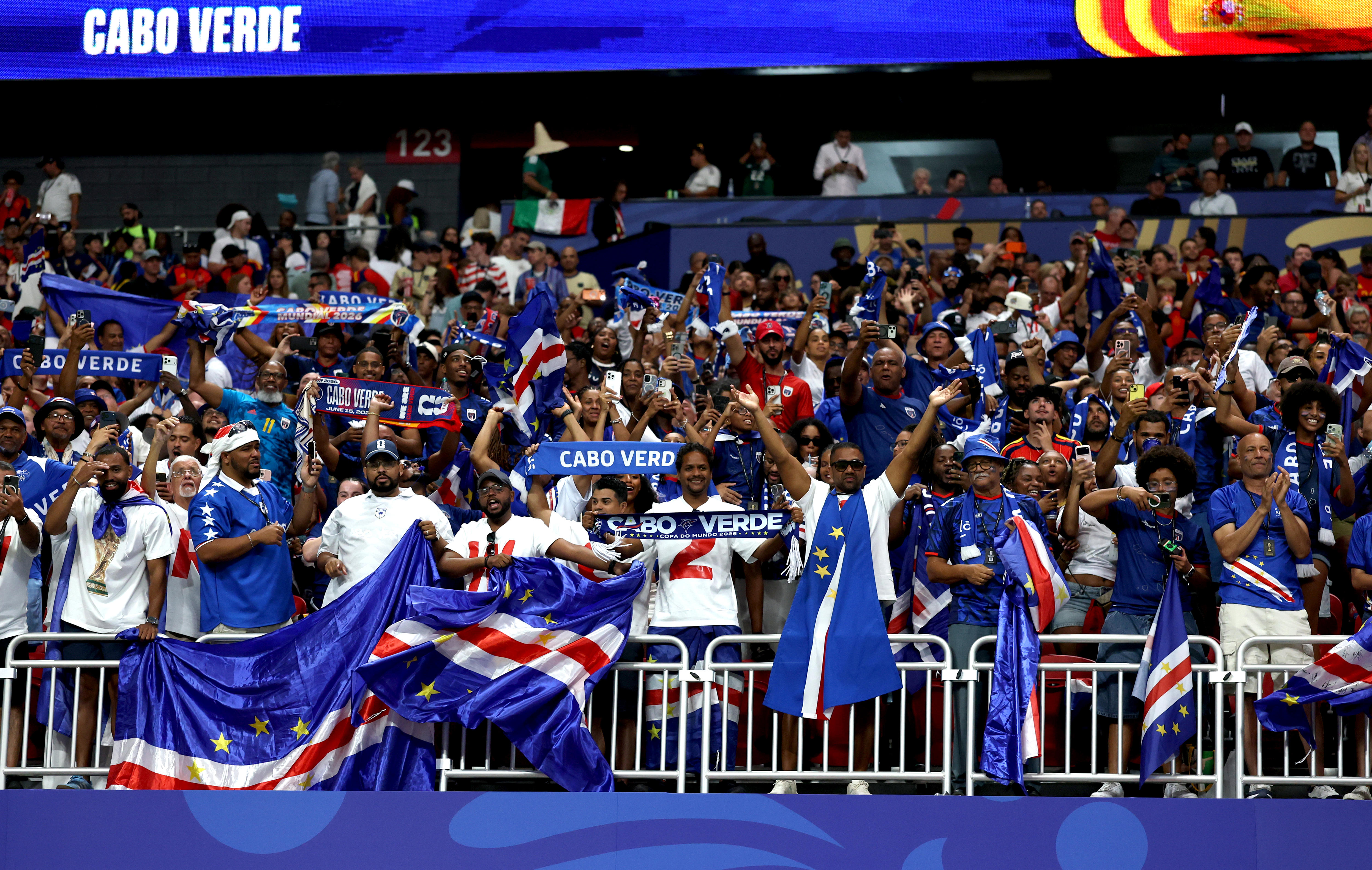 A wide shot of a group of Cabo Verde fans in the crowd