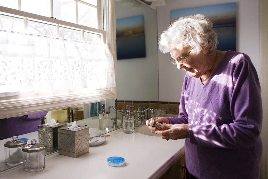 Older woman taking a pill