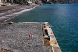 A couple walk along a dock on Italy's Amalfi Coast.