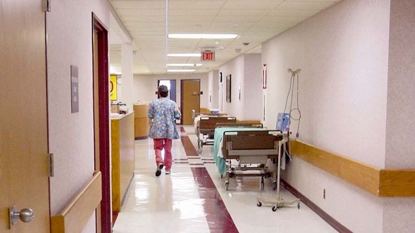 A nurse walks down a hospital corridor