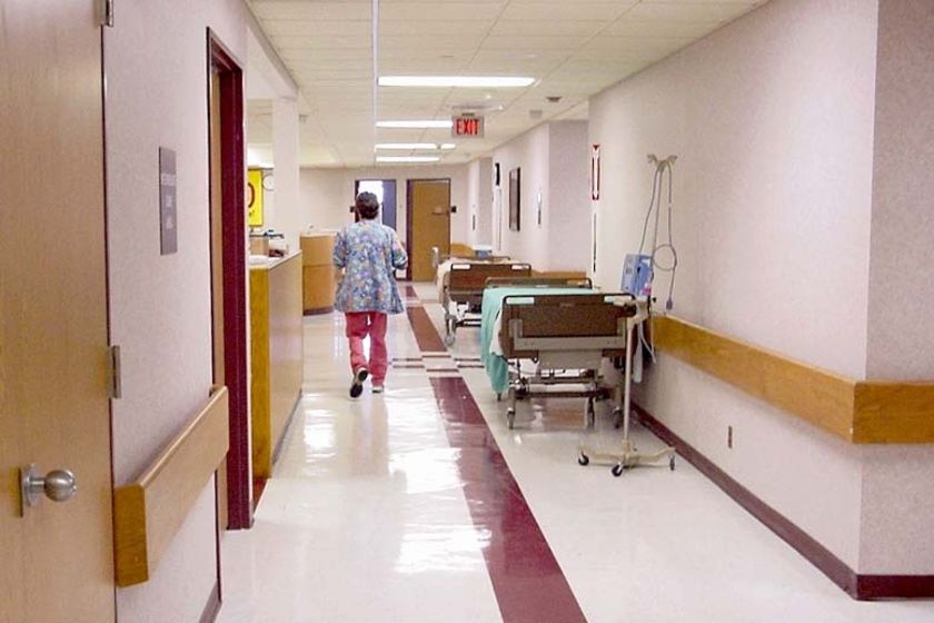 A nurse walks down a hospital corridor