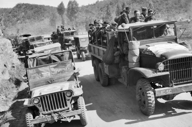A black-and-white image of a convoy of trucks in the Korean War