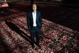 Treasurer Josh Frydenberg stands in a courtyard at Parliament House, looking serious.