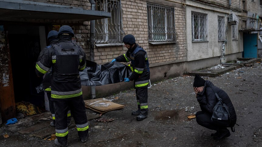 Lilia Kristenko, 38, cries as city responders collect the dead body of her mother Natalia Kristenko in Kherson.