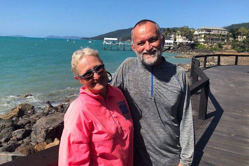 Dr John Hadok and his wife Janice Quadrio standing near the water at Airlie Beach.