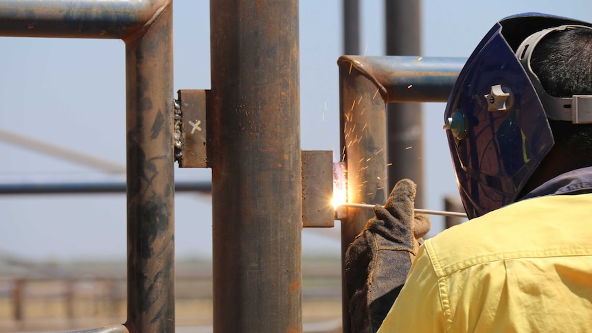 An unidentified prisoner welding a fence at the Livingston abattoir being built near Darwin