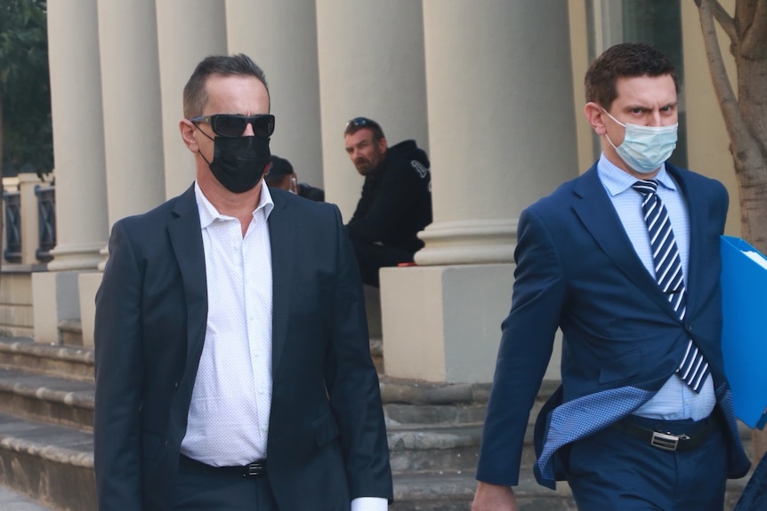 Peter James De Mouilpied in sunglasses and a facemask