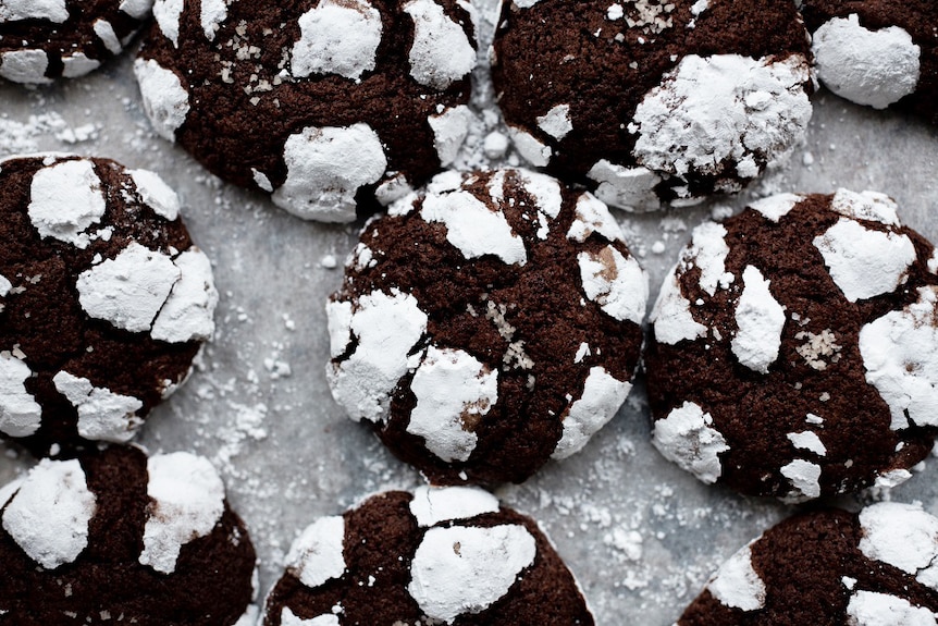 Close-up of a batch of dark chocolate crinkle cookies, a delicious dessert.