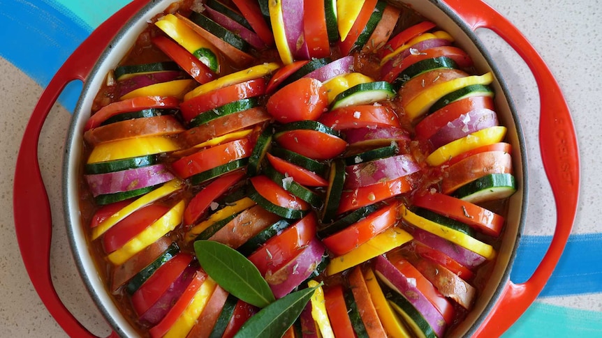 Slices of vegetables in a baking tray ready to be baked into a vegetarian side for a sharing.