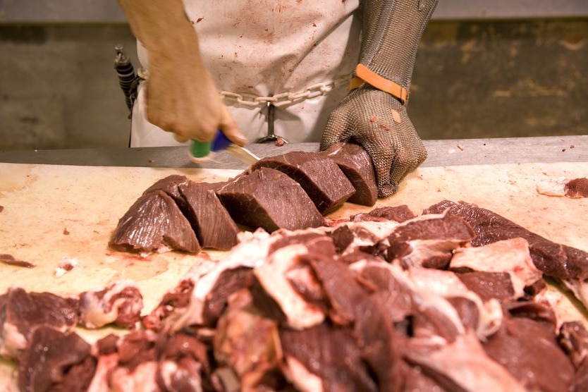 A worker slices feral camel meat