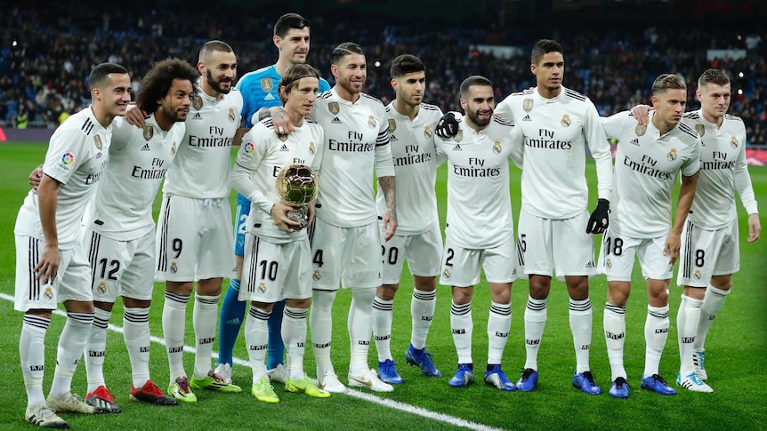 Real Madrid's Luka Modric holds his Ballon d'Or (Golden Ball) award with his teammates.