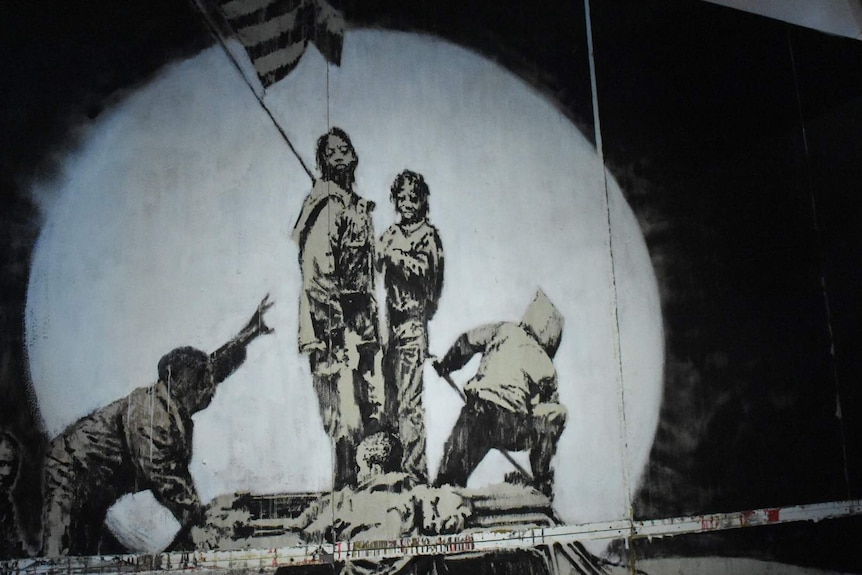 "Flag Wall" is a large-scale piece featured in the Art of Banksy exhibition