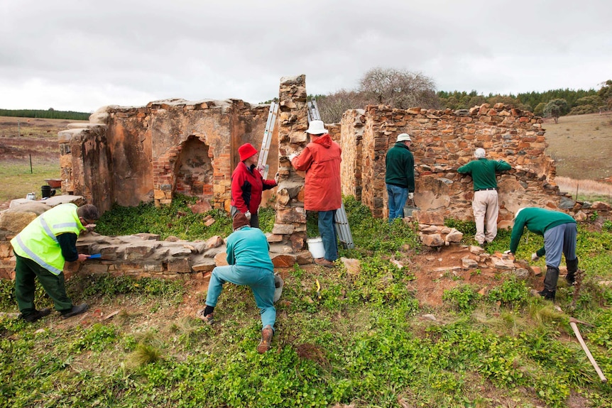 Volunteers work to protect and conserve the walls of Colliers Homestead
