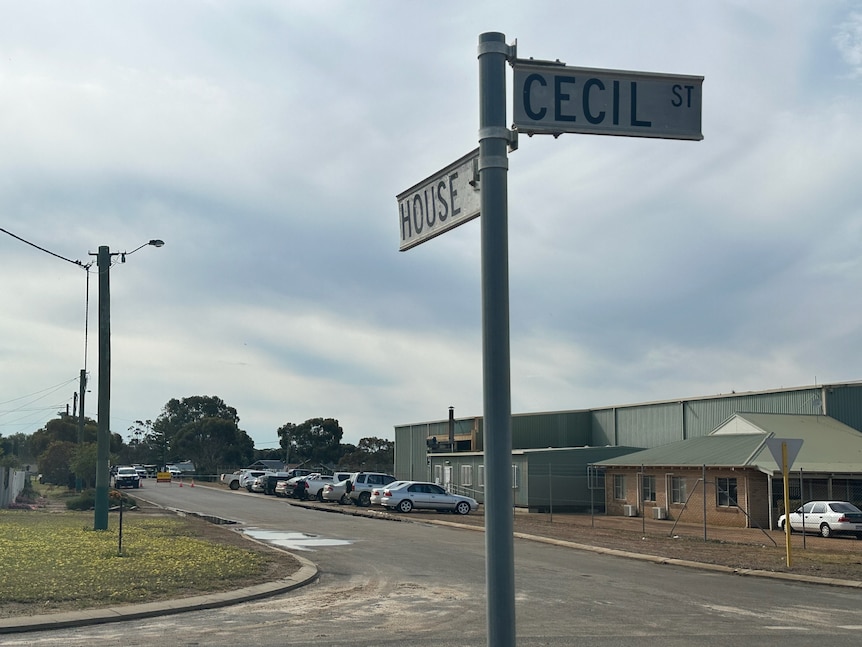 A street sign at an intersection in a residential area in a small town.