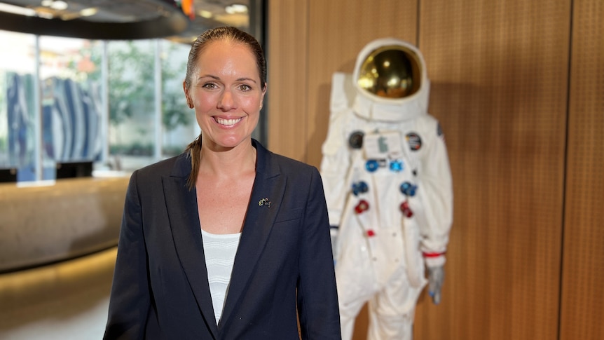 Katherine stands in front of a model of an astronaut at the Australian Space Agency
