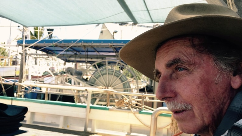 Bruce Batch sits on board his boat, the FV Sydney Lewis, in the port of Cairns