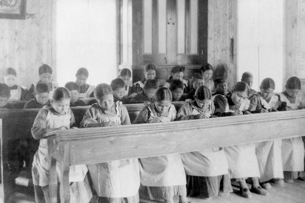 A black and white photo of girls in a classroom.