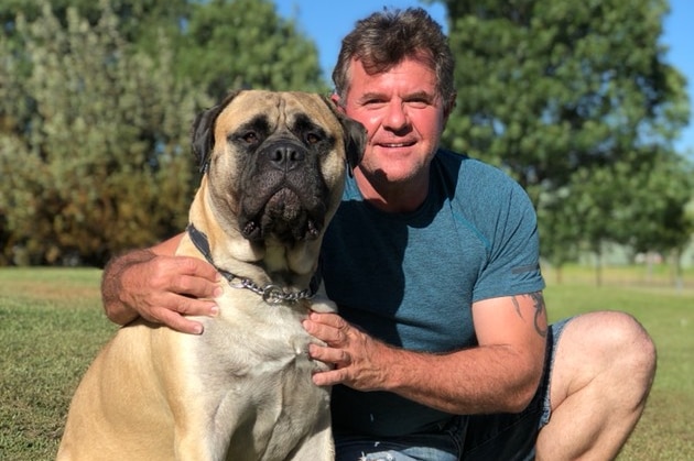 Mr Lee poses with his dog in a park.