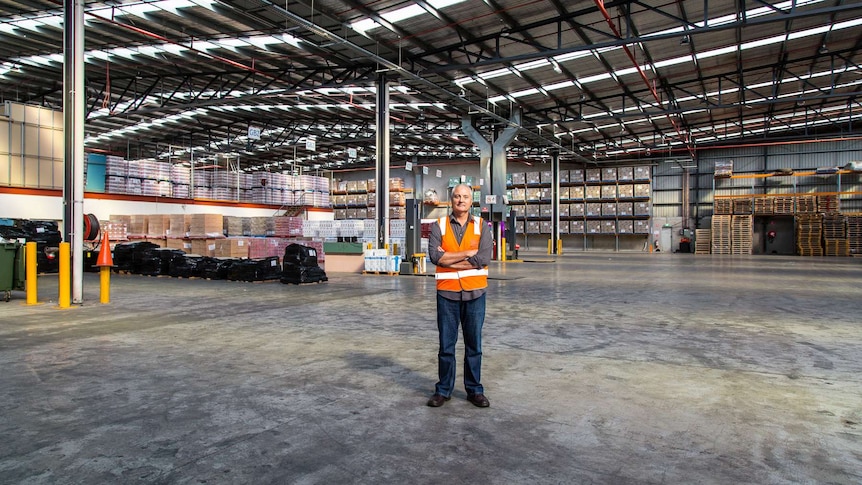 Foodbank Victoria CEO Dave McNamara standing in a huge Foodbank warehouse.