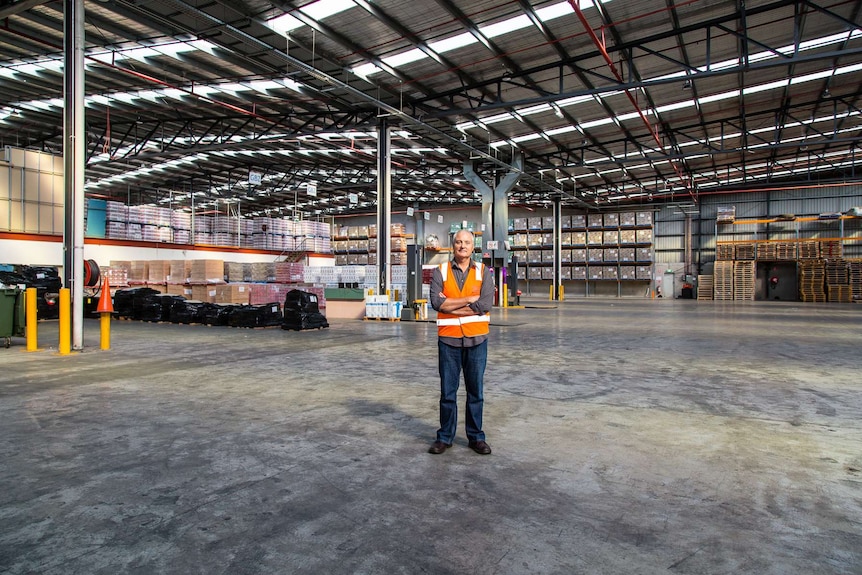 Foodbank Victoria CEO Dave McNamara standing in a huge Foodbank warehouse.