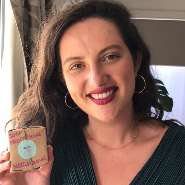 Rachel Shearer smiling and holding a bar of soap in her hand