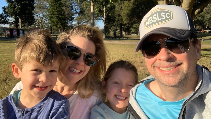 A selfie of, left to right, a young boy, woman, young girl, and man at the park. 