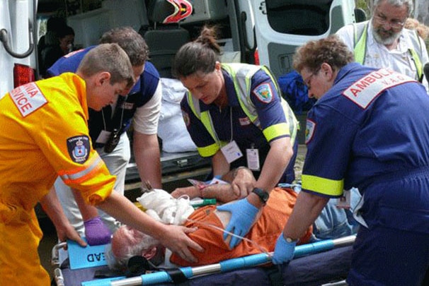 Ambulance Tasmania staff attend to person on gurney near ambulance.