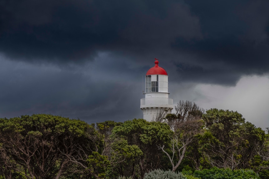 Ominous storm clouds behind a lighthouse.