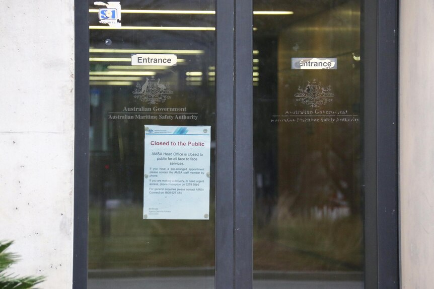 Glass doors with a notice informing the building is closed to the public.