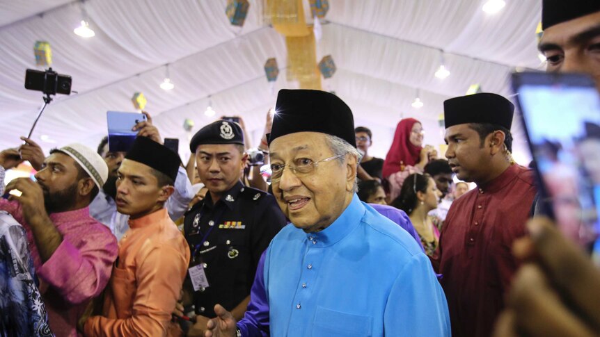 Malaysian Prime Minister Mahathir Mohamad arrives for an Eid celebration in traditional clothing.