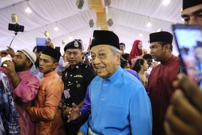 Malaysian Prime Minister Mahathir Mohamad arrives for an Eid celebration in traditional clothing.