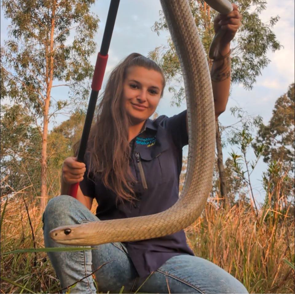 Uma mulher segura uma cobra.