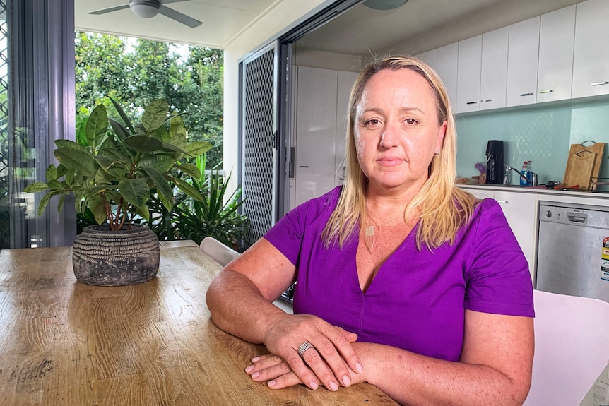 Lisa sits at her kitchen table.